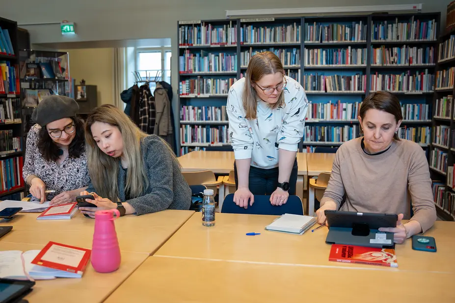 Opiskelijat ja opettaja Opistotalon kirjastossa