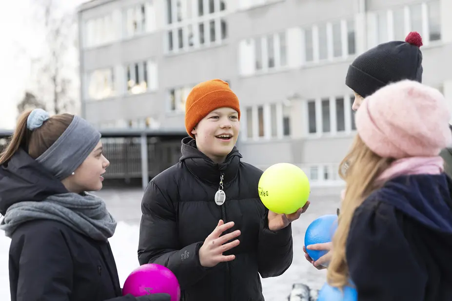 Tukioppilaita koulun pihalla pallojen kanssa