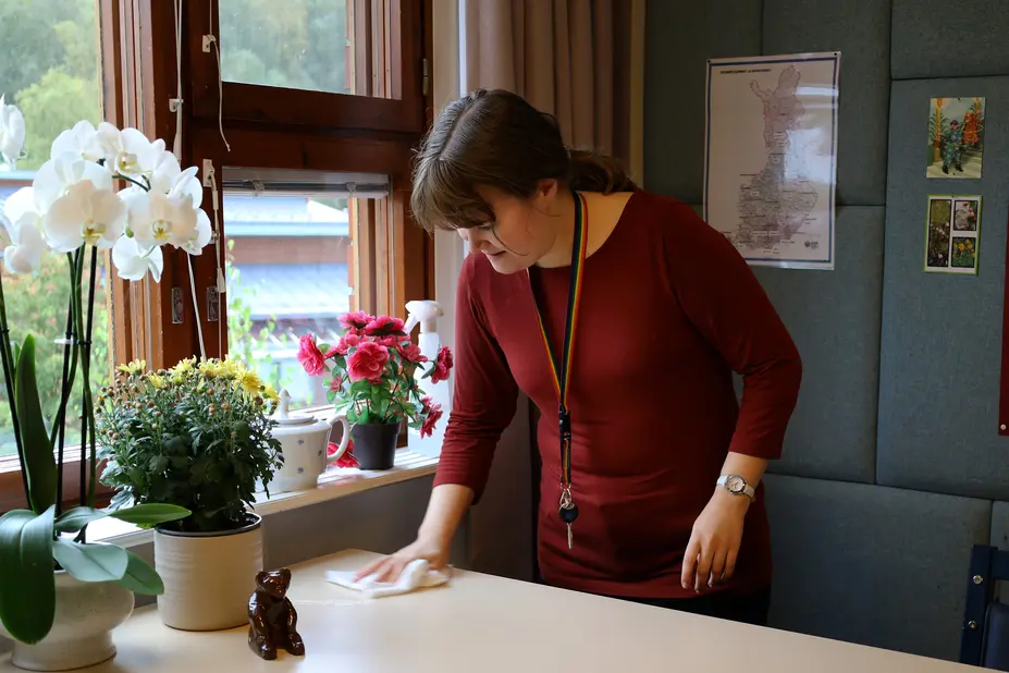 Tuuli, who is employed with wage subsidy, concentrates on wiping the table.