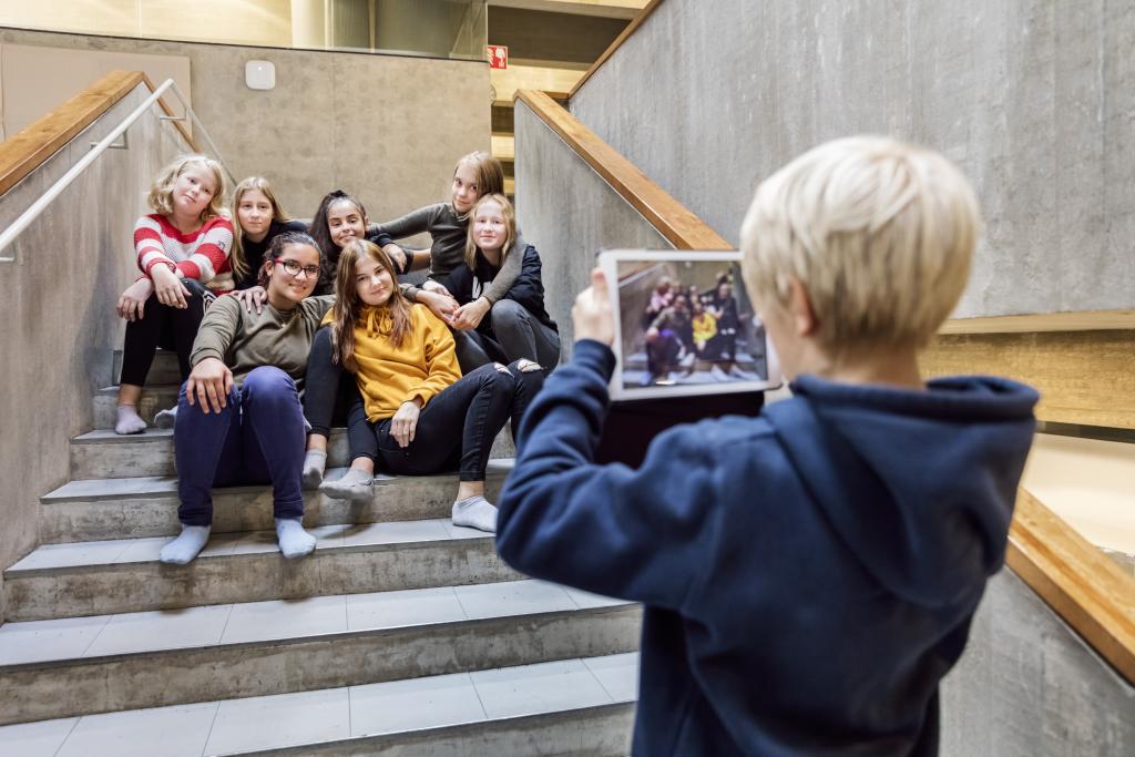 Pupil taking a group photo with a tablet.