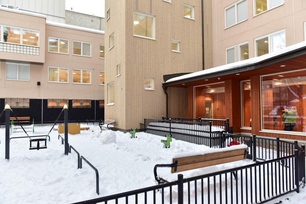 The wooden exterior wall conceals the foyer of the daycare centre and the stairwell connecting the floors, which were placed on the courtyard side as the building was expanded.  Photo: Teina Ryynänen