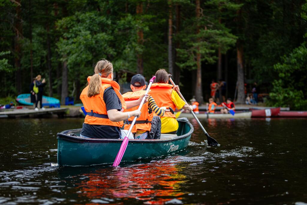 Young people canoeing on a lake.