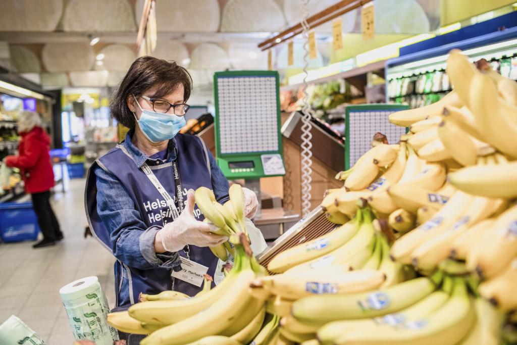 Helsinki Aid -anställd under en kunds shoppingbesök under coronaviruspandemin 2020. Bild: Paula Virta