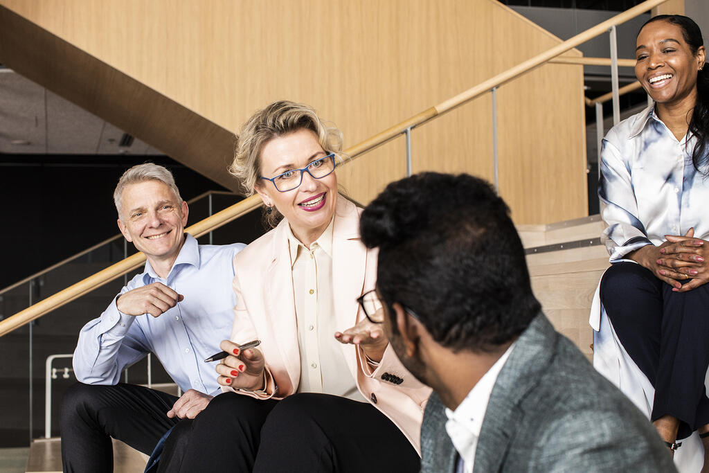 Group of people is talking and smiling together.