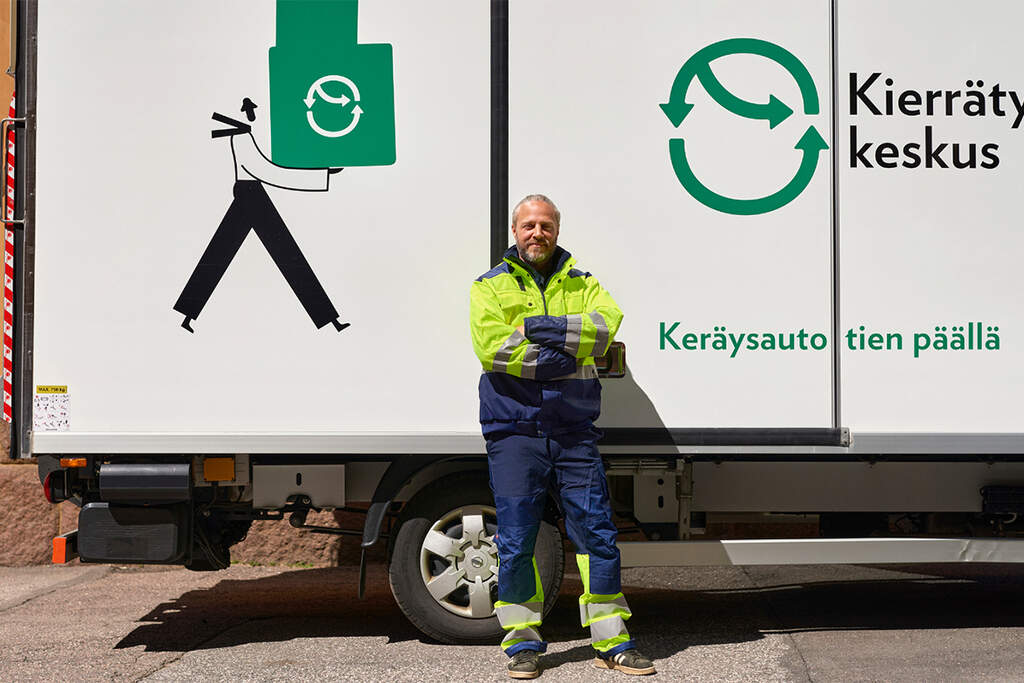Pääkaupunkiseudun Kierrätyskeskuksen työntekijä seisomassa keräysauton edessä.  Kuva: Pääkaupunkiseudun kierrätyskeskus