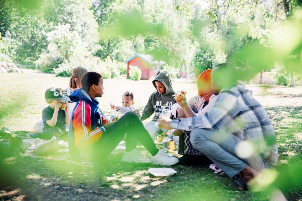 Ungdomar på picknick i en park.