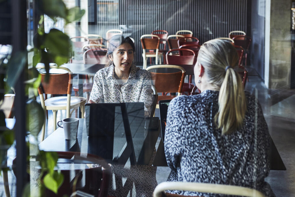 Two women having a business conversation in a café.
