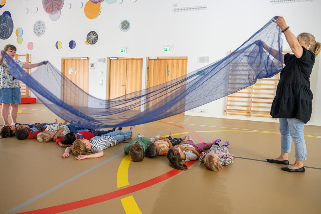 Children in pre-primary education get to relax in the middle of the day, the session is led by Helena Raappana and Päivi Tierto. Photo: Kirsi Riipinen