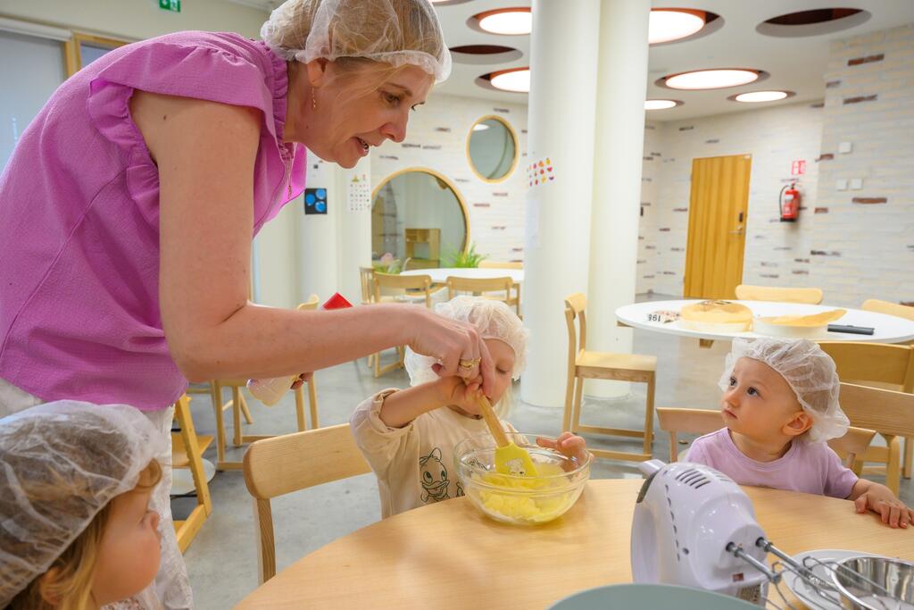 The Pilvenhattara group is experiencing the highlight of the day: they got to bake apple pie under the instruction of early childhood education teacher Minna Saarenoksa. Photo: Kirsi Riipinen