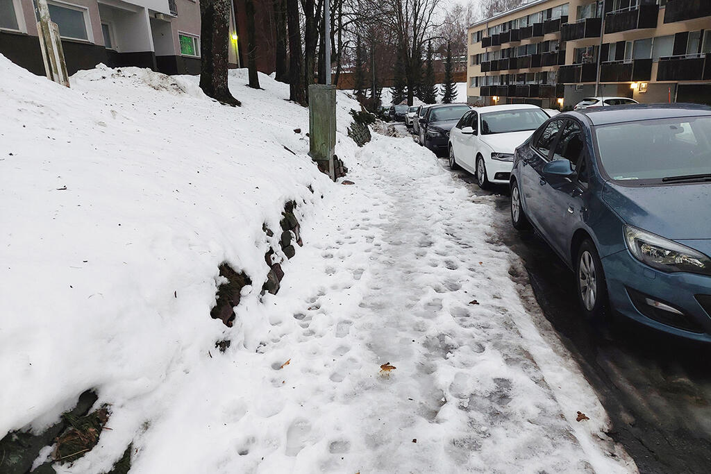 Nykytilanteessa kapea jalkakäytävä päästään puhdistamaan lumesta vasta, kun pysäköidyt ajoneuvot on siirretty pois aurauskaluston tieltä. Kuva: Helsingin kaupunkiympäristö.