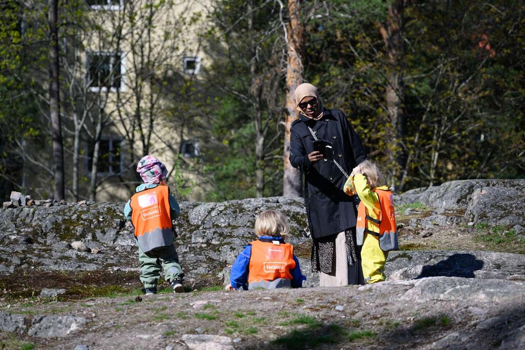 Lastenhoitajaksi oppisopimuksella opiskeleva Farah Diriye metsäretkellä päiväkotilasten kanssa. Kuva: Jussi Helttunen
