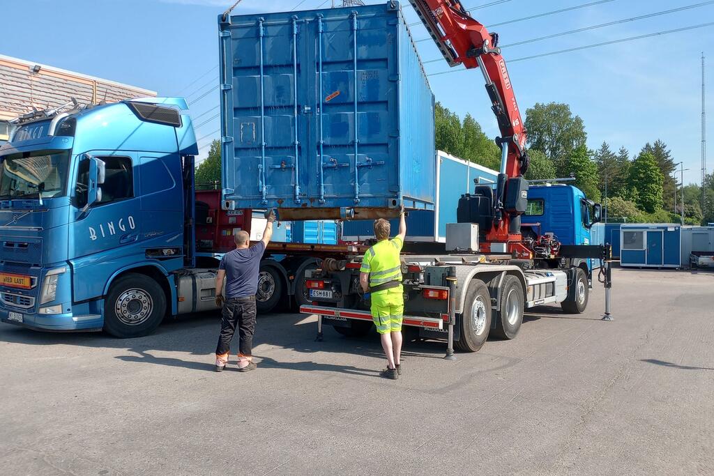 A sea container is loaded onto a lorry.