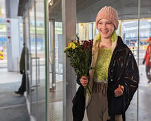 Oodin kymmenes miljoonas kävijä Sonja Oodin ulko-ovilla kukkakimppu kädessään.