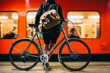 Matkustaja odottaa laiturille saapuneeseen metroon nousemista polkupyöränsä kanssa.