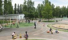 Yleiskuva leikkipuistosta, jossa leikkiviä lapsia.