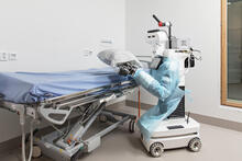 Välkky-robotti potilaan sängyn luona.