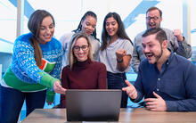 En grupp med elever runt en dator.