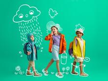 Kolme lasta, piirrettynä aurinkoa ja sadetta päällä
