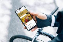 Pyöräilijä katsoo mobiilissa Helsingin kaupungin nettisivujen uutta etusivua.