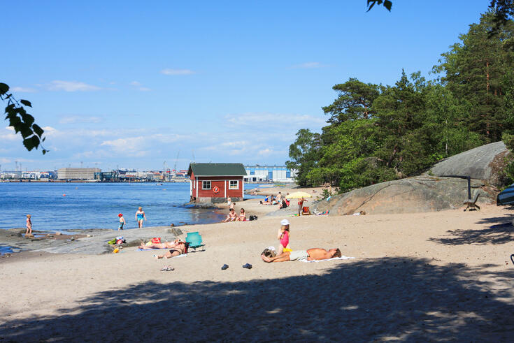 Auringonottajia Pihlajasaaren uimarannalla.