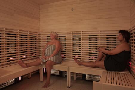  Kaksi ihmistä istuu silmät kiinni Yrjönkadun uimahallin infrapunasaunassa.