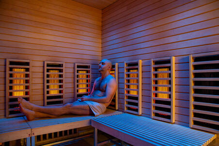 Saunan lauteilla istuu henkilö.