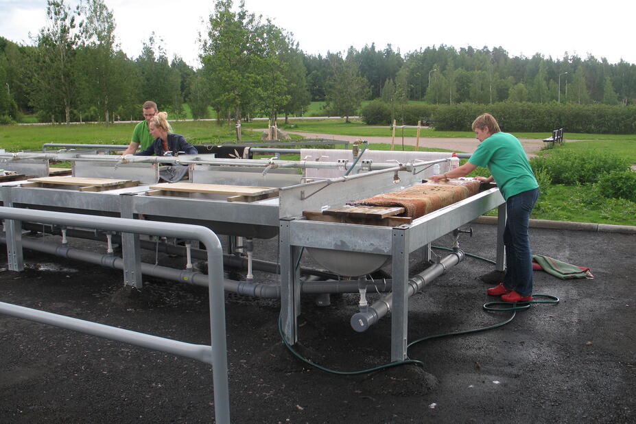 Ihmisiä matonpesupaikalla