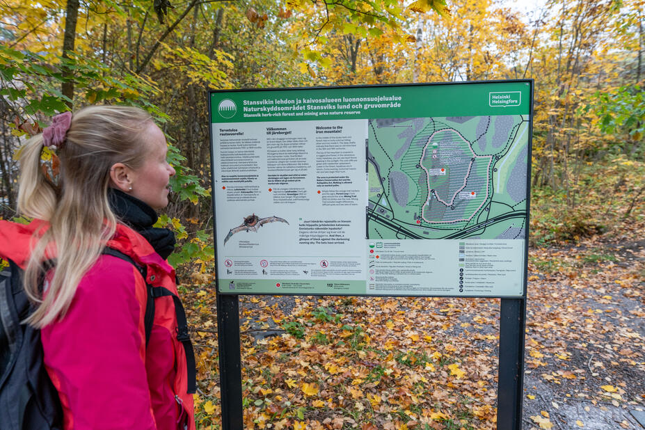 Ulkoilija lukemassa opastaulua Stansvikissa.