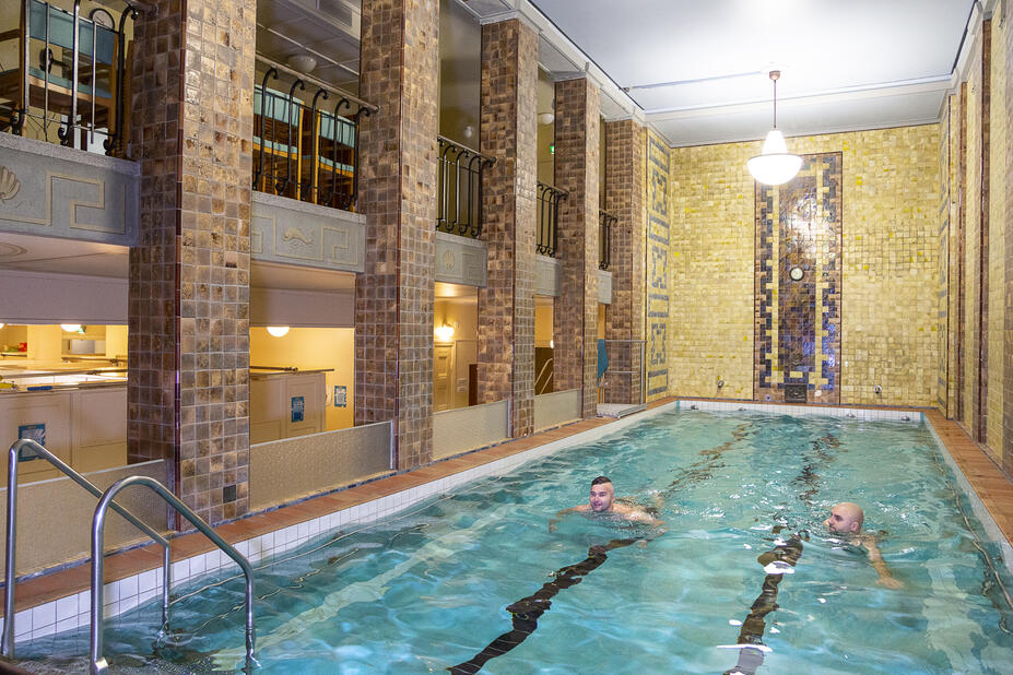 Pienehkö uima-allas ja kaksi uimaria.