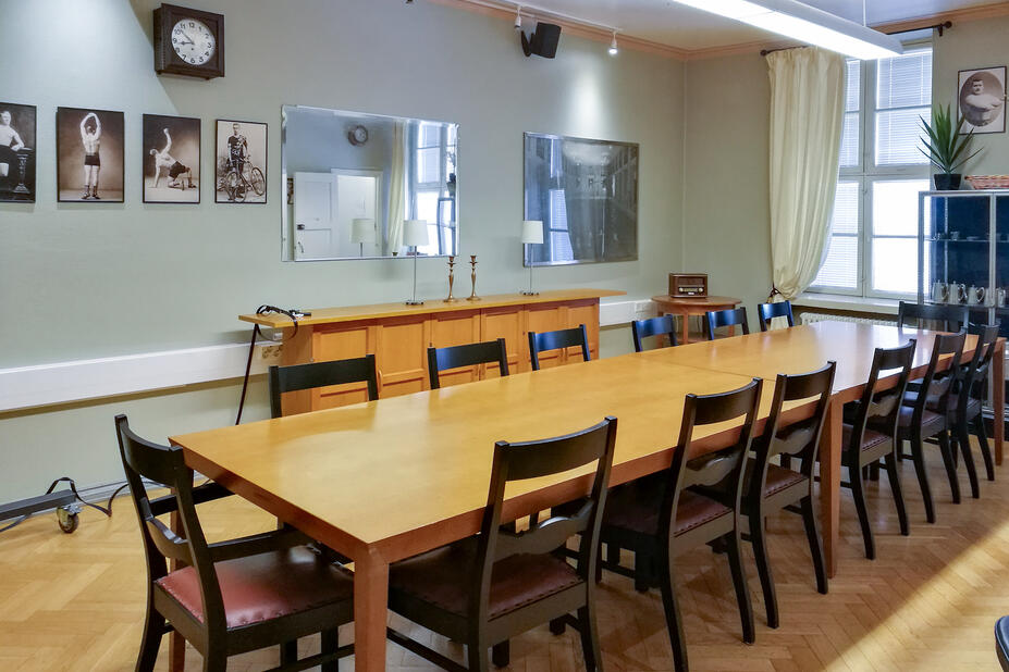 Neuvotteluhuone, pöytä ja kymmenisen tuolia.