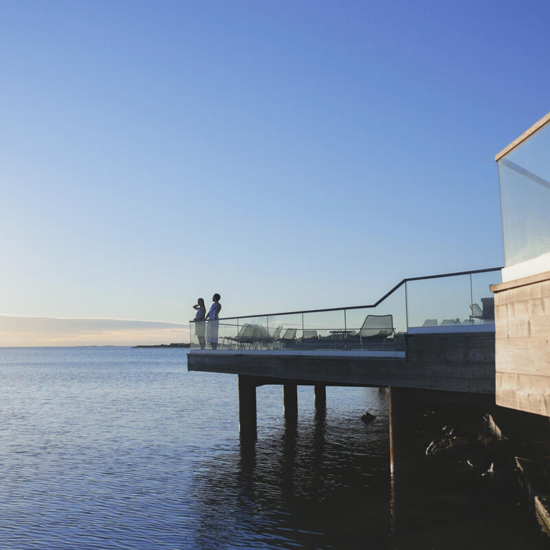 Moderni puinen sauna ja terassi meren äärellä.