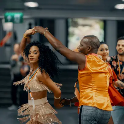 En man och en kvinna dansar på gatan i färgglada kläder