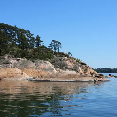 Kallioinen ranta ja tyyni meri.