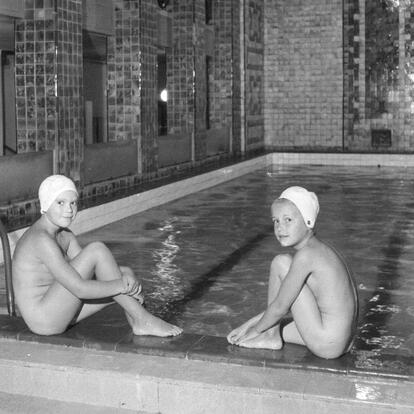 Uima-allas ja kaksi lasten istumassa sen edustalla.