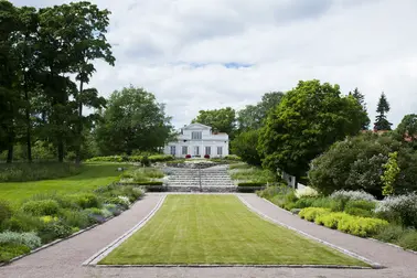 Perennplanteringar i parken vid Villa Anneberg och villan i bakgrunden.