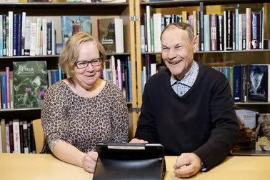 Person helping a senior citizen with a tablet