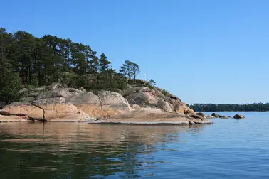 Kallioinen ranta ja tyyni meri.