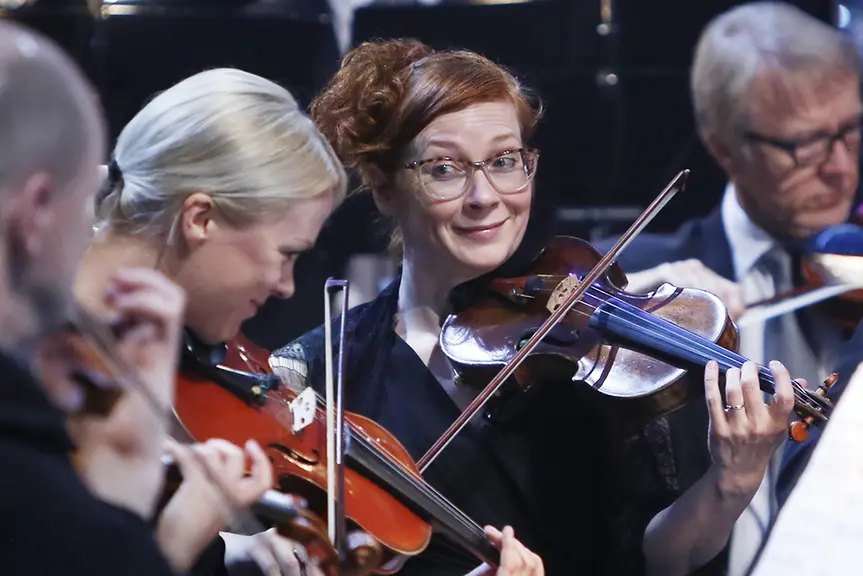 Violinists of the city orchestra playing the violin.