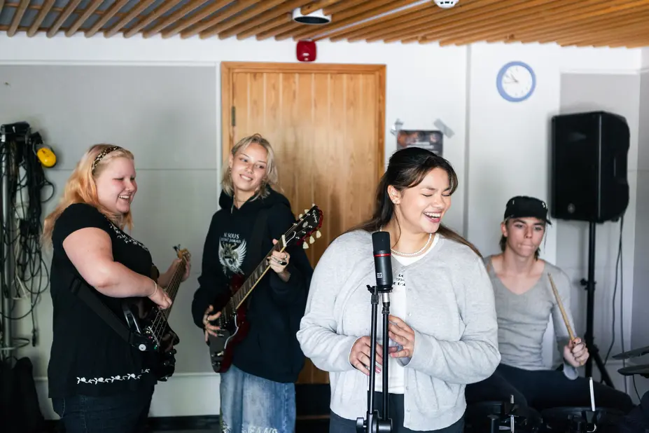 Four young people are playing in a band together.