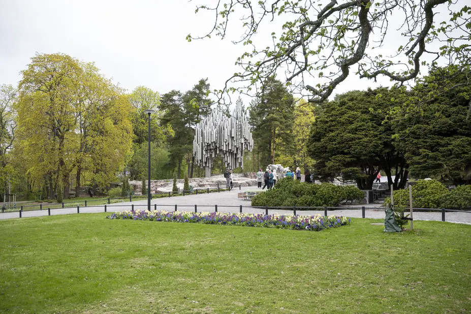 Sibelius-monumentti Sibeliuksenpuistossa ja keväisiä istutuksia.