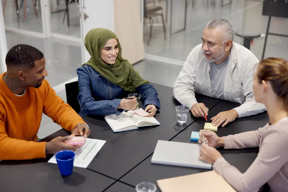 Four adults are having a meeting at the table. 