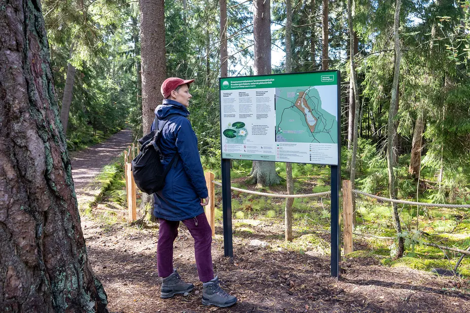 Nainen tutkii kartallista opastaulua. 