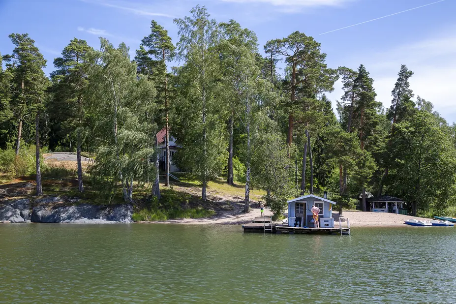 Saaren rantaviiva ja puinen pieni mökki veden päällä.