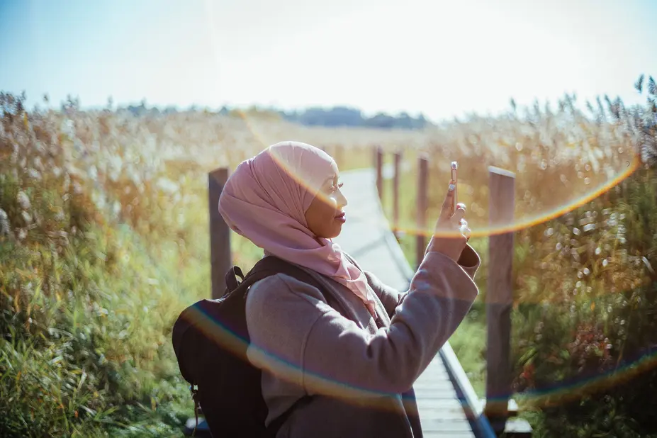 A woman taking pictures on her cell phone.