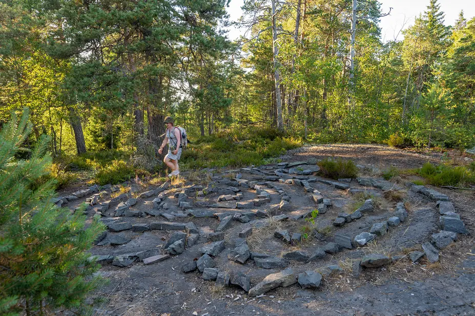 Nainen kävelee kivilabyrintissa.