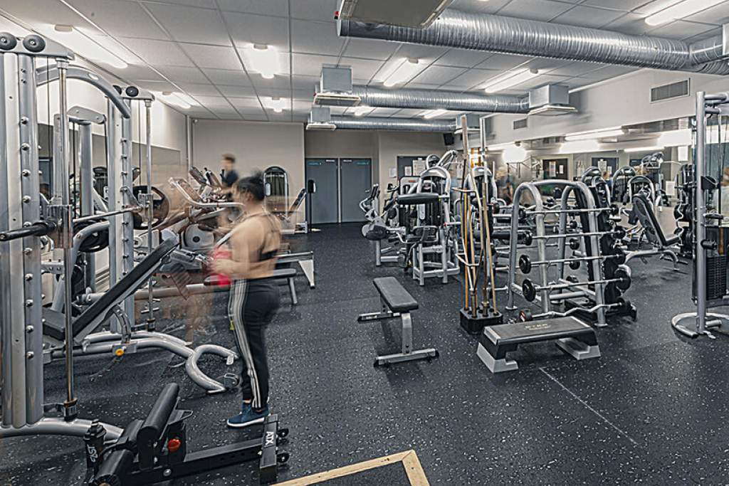 En kvinna använder gymutrustning på gymmet i Ladugårdens idrottshall.