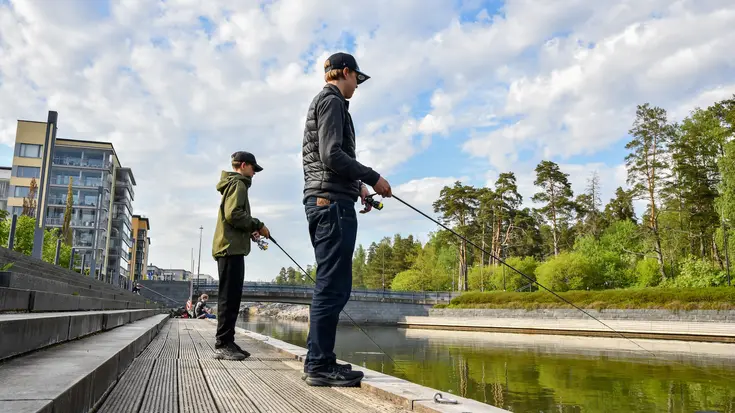 Kaksi nuorta kalastaa Aurinkolahdessa.
