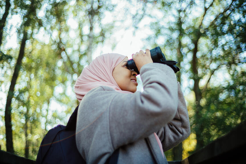 Woman with binoculars in the nature