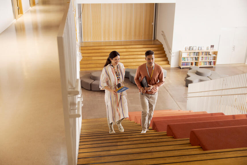 Opettajat kävelevät koulun portaissa.