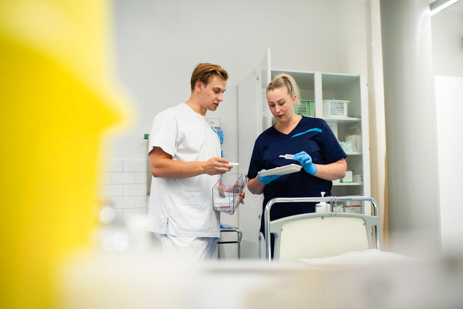 Sairaanhoitajat keskustelemassa työn lomassa.